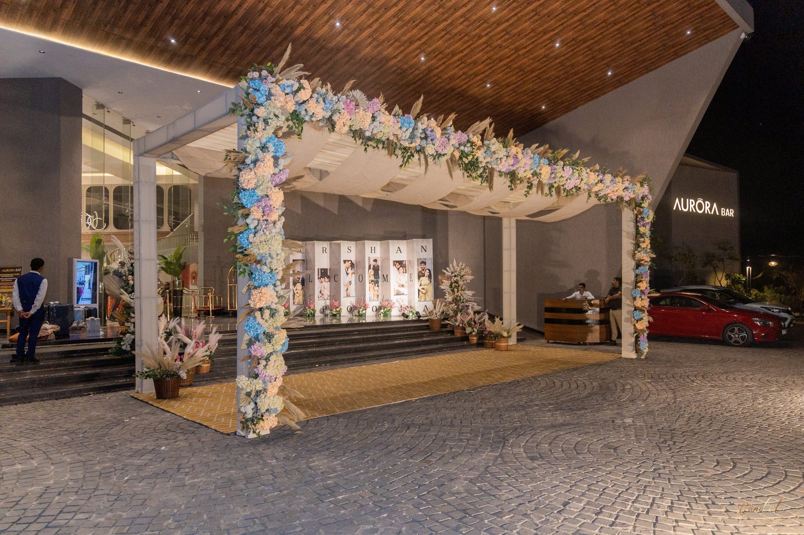 Floral welcome arch leading guests into the venue at night