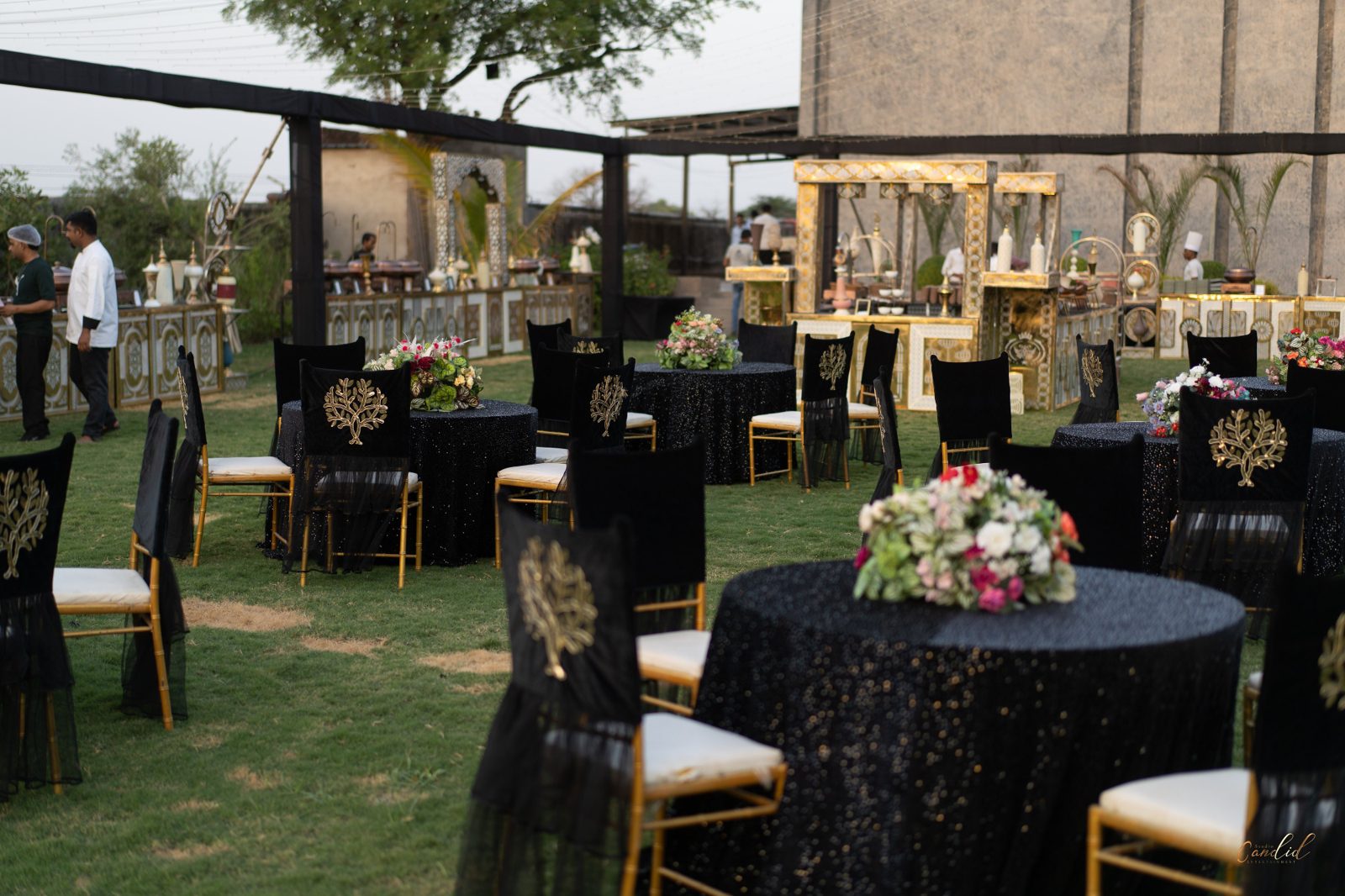 Black and gold themed reception tablescape with monogrammed chair drapes