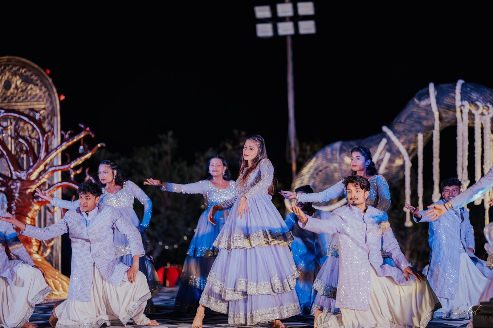 Choreographed dance performance in coordinated silver and blue outfits