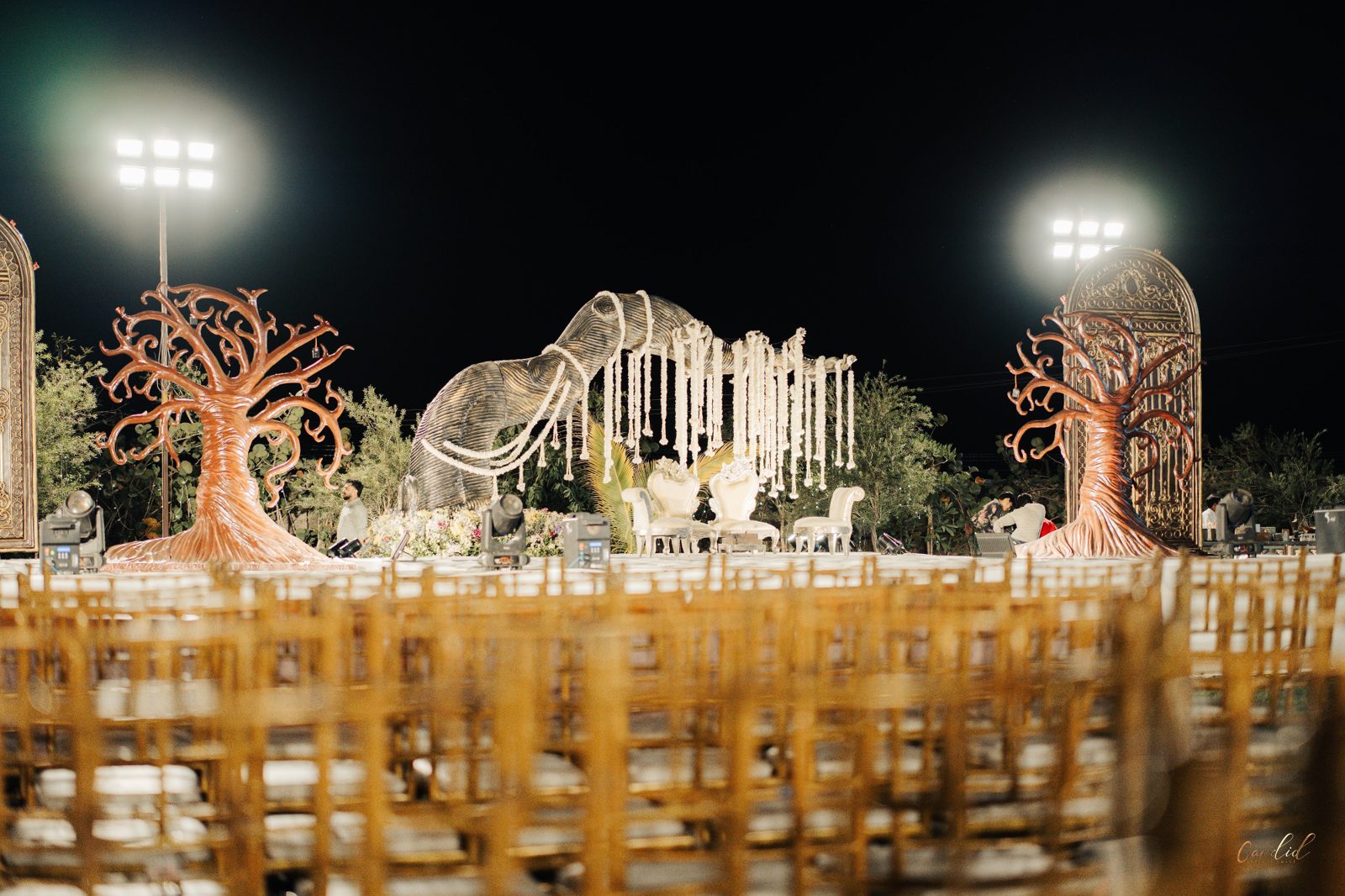 Sculptural elephant installation draped in cascading white florals over the couple's seating
