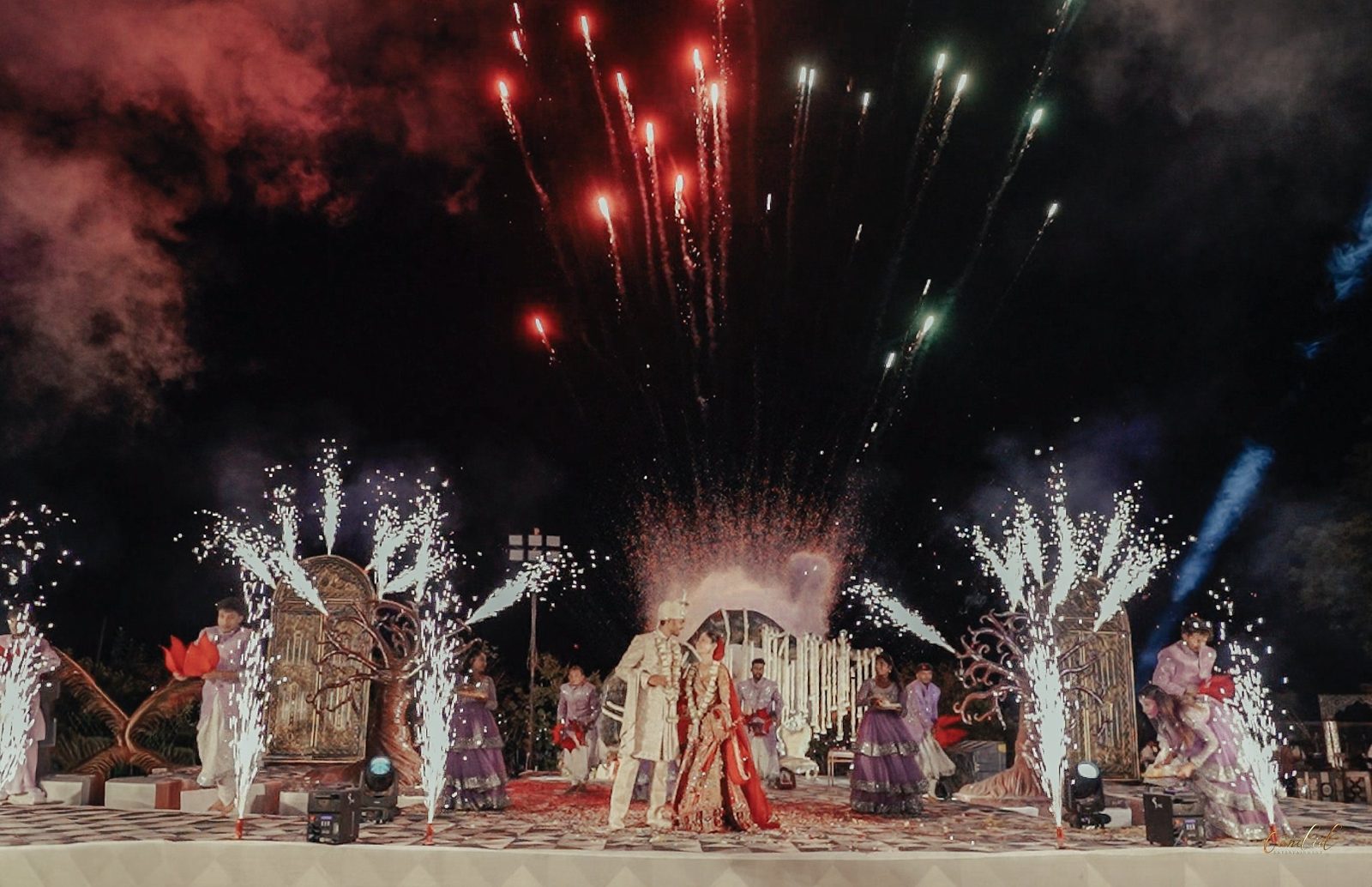Couple walking through fireworks and cold sparklers after the ceremony